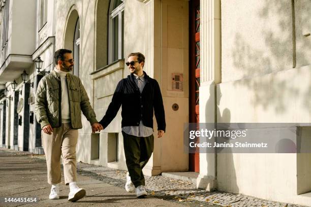 loving gay couple walking down the street in autumn - europa central fotografías e imágenes de stock