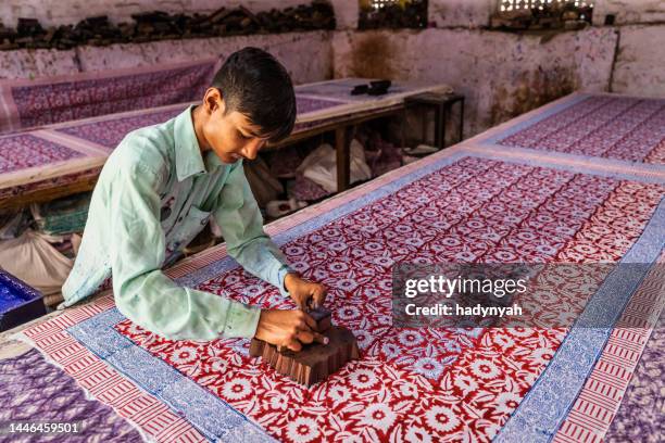 junger mann bei der arbeit in einer blockdruckerei in jaipur, indien - jaipur stock-fotos und bilder