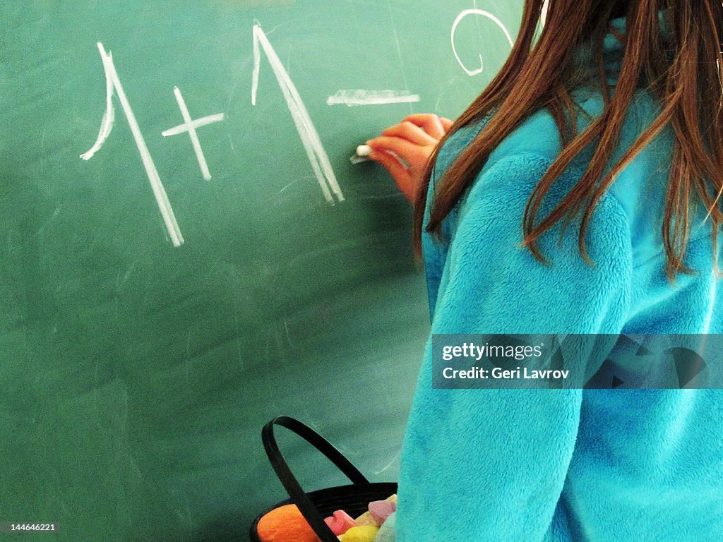 Child writing on blackboard