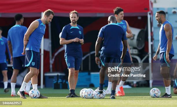 Gareth Southgate, Head Coach of England, looks on beside Harry Kane of England during the England training session on match day -1 at Al Wakrah...