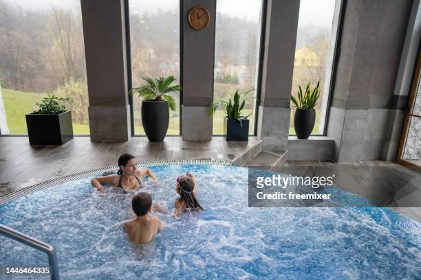 young family enjoying vacation in luxury hotel - girls in hot tub stockfoto's en -beelden