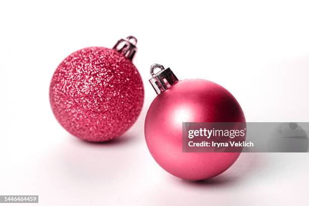 two christmas balls in red viva magenta color of the year 2023 on white color background. - glitter ball stock-fotos und bilder