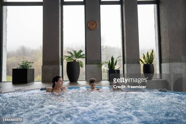 young family enjoying vacation in luxury hotel - girls in hot tub stockfoto's en -beelden