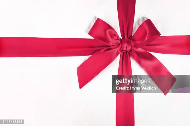 xmas present, gift, congratulation.  winter holidays and black friday concept with gift box and  tied bow in trendy viva magenta color of the year 2023 color. - geschenkschlaufe stock-fotos und bilder