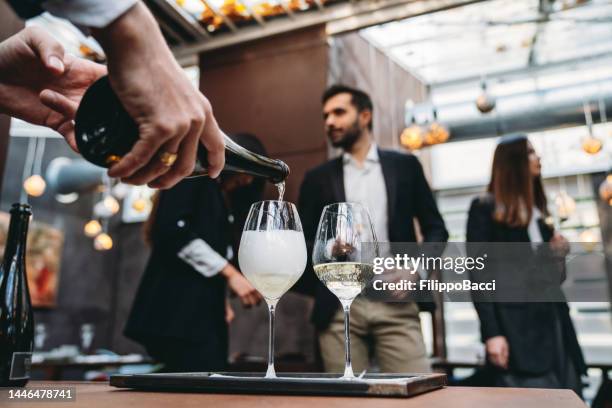 ein kellner gießt im restaurant prosecco in gläser - prosecco stock-fotos und bilder