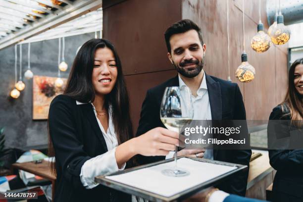 a waiter is serving wine to the clients for the aperitif - chinese waiter stock pictures, royalty-free photos & images