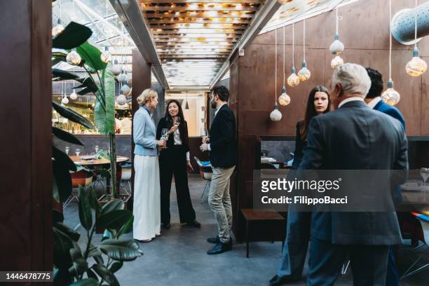 empresarios conversan juntos durante un evento de teambuilding en un restaurante de lujo - hotel de lujo fotografías e imágenes de stock