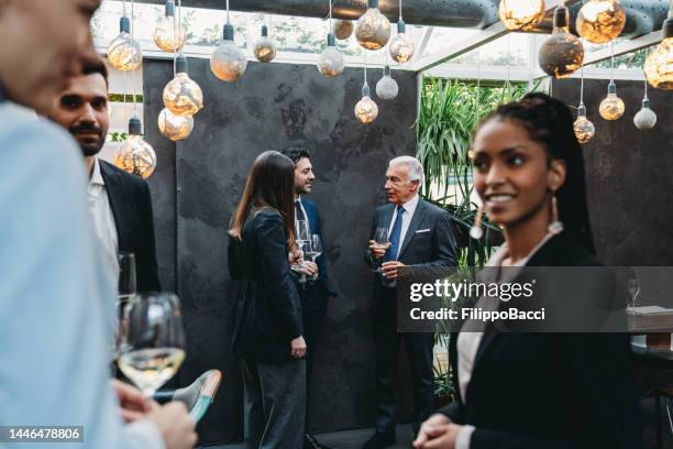 elegant people are talking together in an high-end restaurant during the aperitif - exclusive event stock pictures, royalty-free photos & images