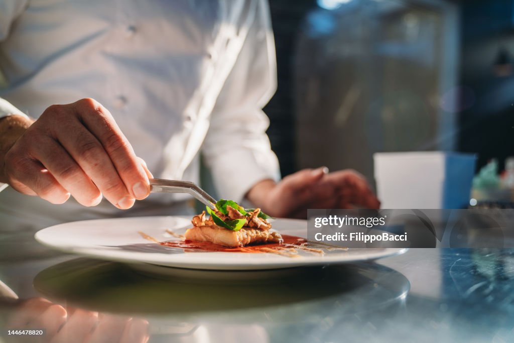 Um chef está terminando a preparação do prato