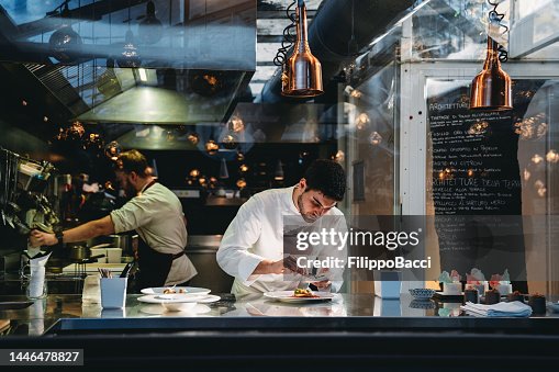 Un chef está cocinando en la cocina de su restaurante Un chef está cocinando en la cocina de su restaurante