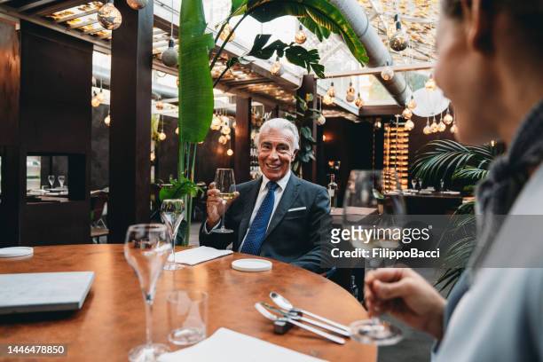 kollegen unterhalten sich im restaurant während eines meetings miteinander - black tie dinner stock-fotos und bilder