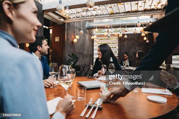 los colegas están disfrutando de una comida en el restaurante durante una reunión - formalwear fotografías e imágenes de stock