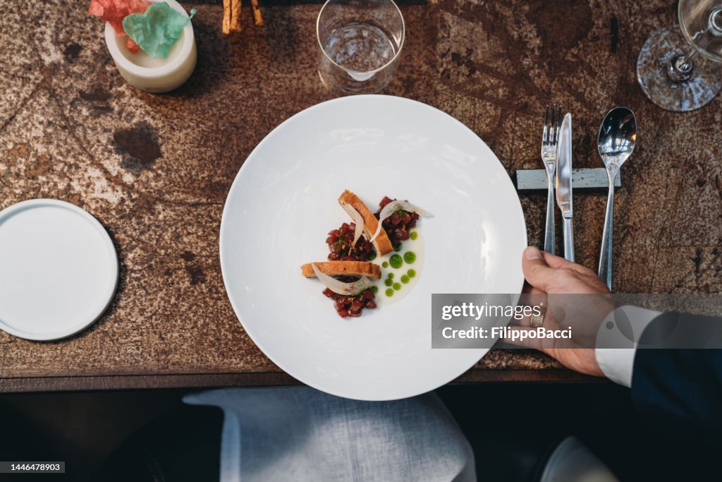 Ein Kellner serviert einen Teller in einem High-End-Restaurant