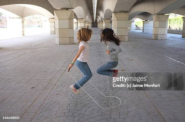 two girls jumping rope - 縄跳びをする ストックフォトと画像