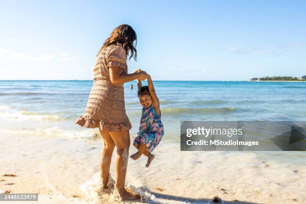 mother and daughter playing on the beach - cute mexican girl 個照片及圖片檔