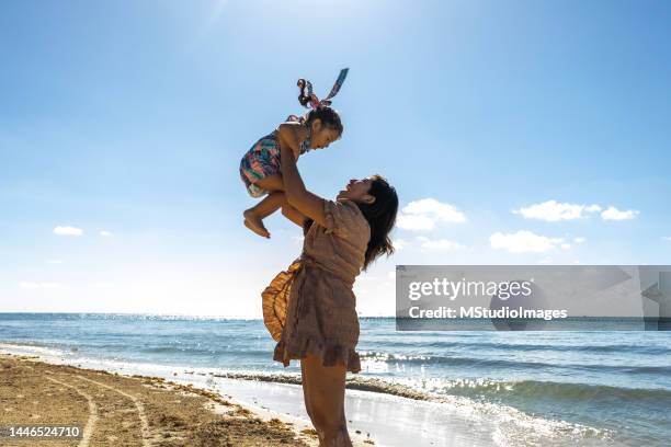 mutter und tochter spielen am strand - tiny mexican girl stock-fotos und bilder