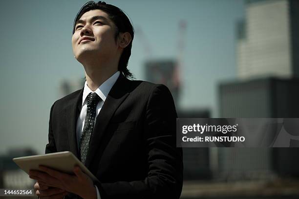 businessman with tablet computer - looking up ストックフォトと画像