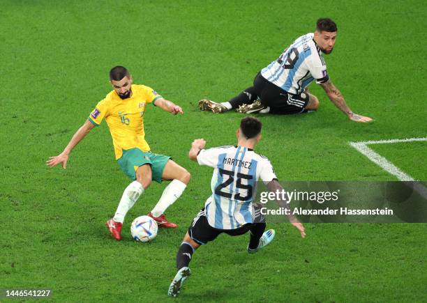 Aziz Behich of Australia shoots the ball against Lisandro Martinez and Nicolas Otamendi of Argentina during the FIFA World Cup Qatar 2022 Round of 16...