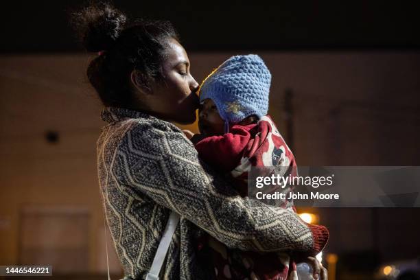 An immigrant from Mexico kisses her baby while in a migrant camp on November 30, 2022 in Matamoros, Mexico. Thousands of immigrants have been waiting...