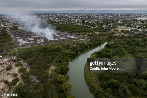 As seen from an aerial view, trash burns on the Mexican side of the Rio Grande on December 01, 2022 near McAllen, Texas. Thousands of immigrants have...