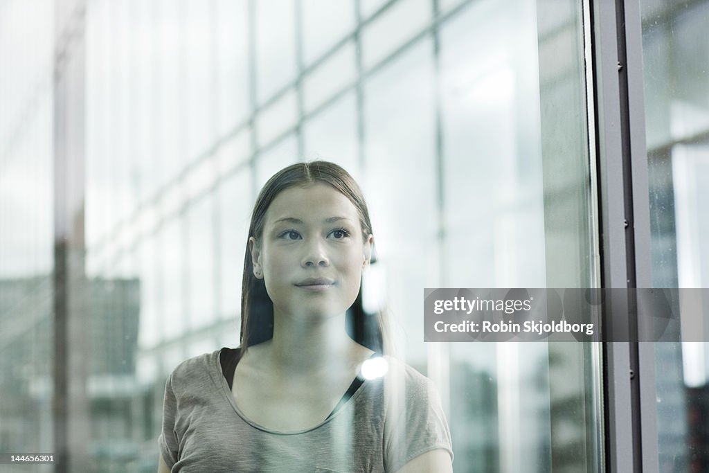 Woman looking out through glass.