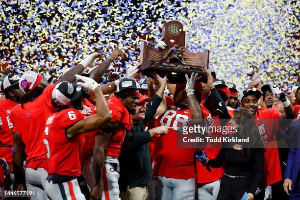 The Georgia Bulldogs celebrate with the trophy after defeating the LSU Tigers in the SEC Championship game at Mercedes-Benz Stadium on December 03,...