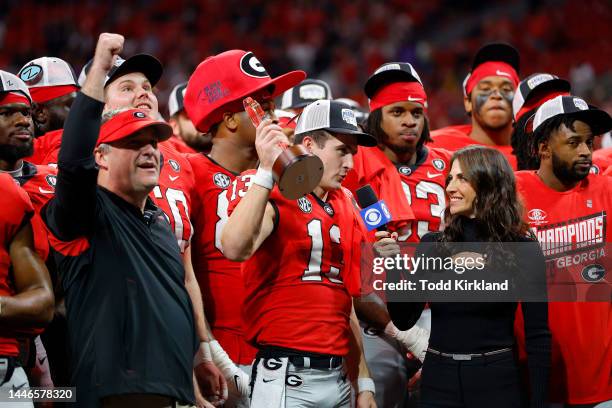 Stetson Bennett of the Georgia Bulldogs celebrates with the MVP trophy after defeating the LSU Tigers in the SEC Championship game at Mercedes-Benz...