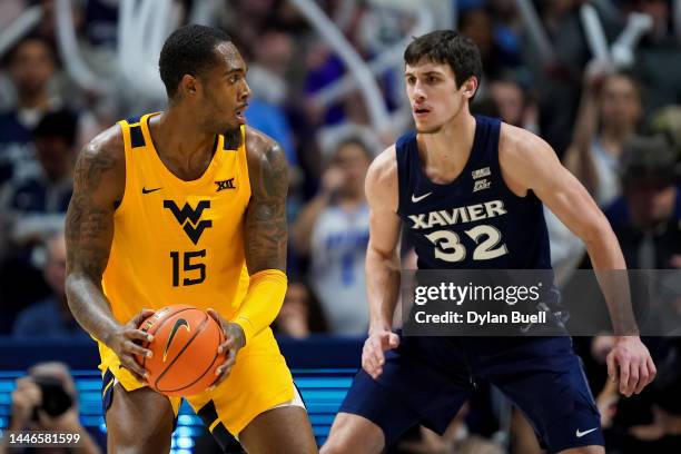 Jimmy Bell Jr. #15 of the West Virginia Mountaineers handles the ball while being guarded by Zach Freemantle of the Xavier Musketeers in the second...