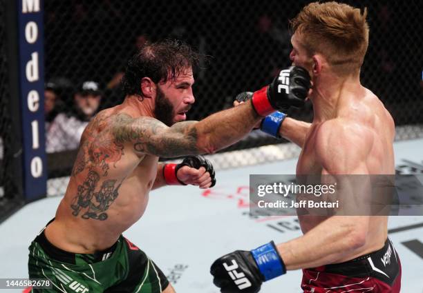 Clay Guida punches Scott Holtzman in a lightweight fight during the UFC Fight Night event at Amway Center on December 03, 2022 in Orlando, Florida.