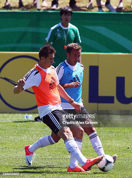 Miroslav Klose is challenged by Mario Goetze during a Germany training session at Campo Sportivo Comunale Andrea Corda on May 17, 2012 in Abbiadori,...