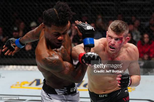 Stephen Thompson punches Kevin Holland in a welterweight fight during the UFC Fight Night event at Amway Center on December 03, 2022 in Orlando,...