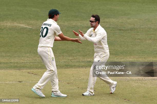 Pat Cummins and Travis Head of Australia celebrate the wicket of Alzarri Joseph of the West Indies during day five of the First Test match between...