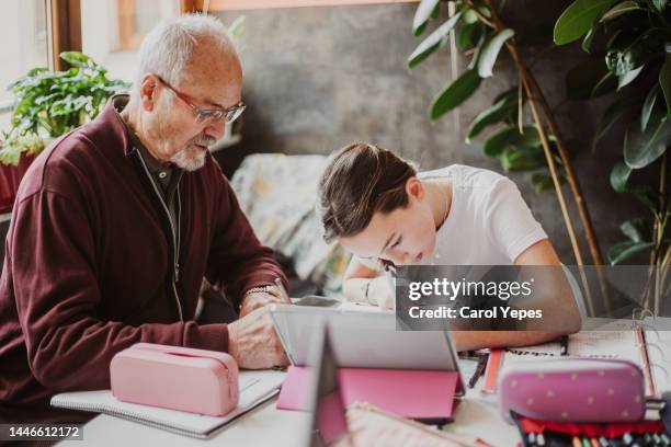 grandpa  helping  grand daughter with home works - confident girl imagens e fotografias de stock