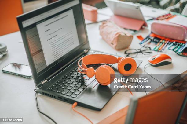 woman home office desk workspace with laptop, headphones  messy office at home - table top imagens e fotografias de stock