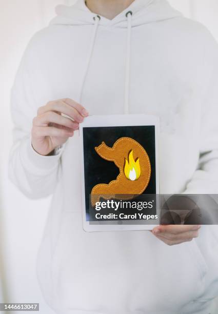 male holding digital tablet with image of stomach with pain - abdominoplastie stock-fotos und bilder
