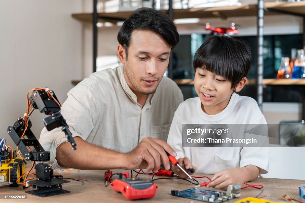 Student Building Rorbot Cheerful Teacher Helps Student Build Robot High-Res Stock Photo - Getty ...