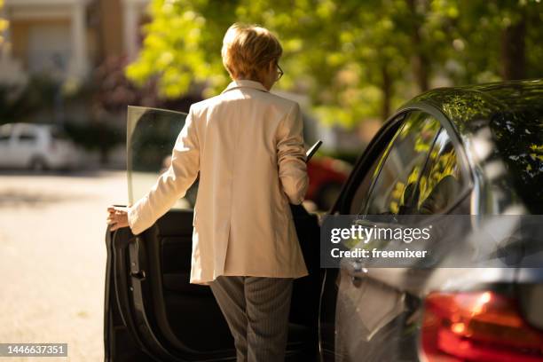 business woman getting into car after work - car door stock pictures, royalty-free photos & images