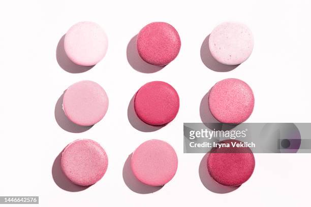 pattern made of tasty  french macaroons or macarons, macaruns in color of the year 2023 viva magenta on white color background. - cupcake box stock pictures, royalty-free photos & images