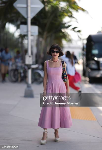 Fidan Ilham seen wearing a pink pleated long dress with plateau heels and a colourful bag on December 02, 2022 in Miami, Florida.