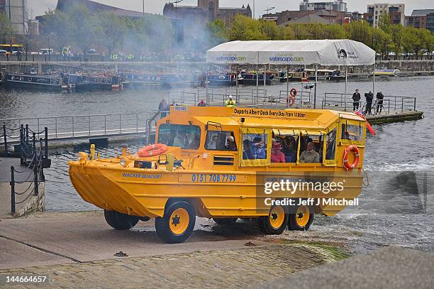 Queen Elizabeth II and Prince Philip, Duke of Edinburgh take a ride on the Yellow Duck and amphibious vehicle during a visit to Merseyside Maritime...