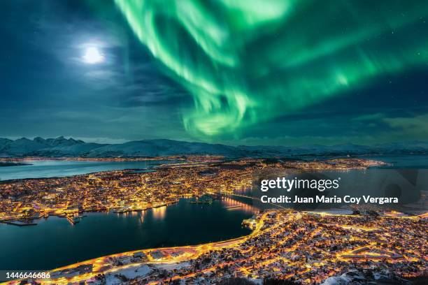 aurora borealis dancing over the city of tromso and full moon, northern norway - soul city ストックフォトと画像