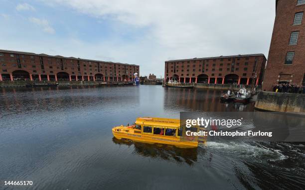 Queen Elizabeth II and Prince Philip, Duke of Edinburgh take a ride on the Yellow Duck amphibious vehicle around Albert Dock during a visit to...