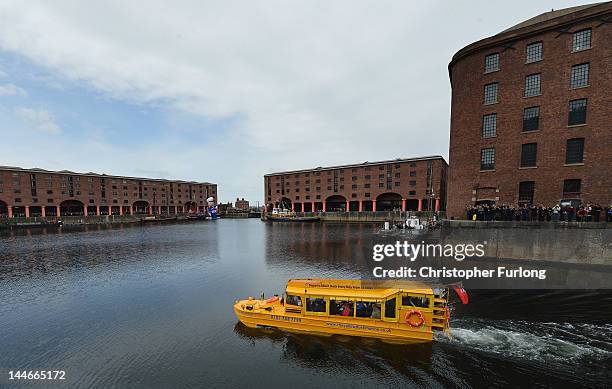 Queen Elizabeth II and Prince Philip, Duke of Edinburgh take a ride on the Yellow Duck amphibious vehicle around Albert Dock during a visit to...