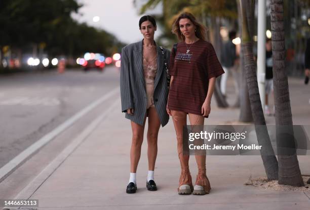 Gilda Ambrosio seen wearing an oversized striped grey blazer, a lingerie laced dress, black loafers with white socks and a guest seen wearing a...