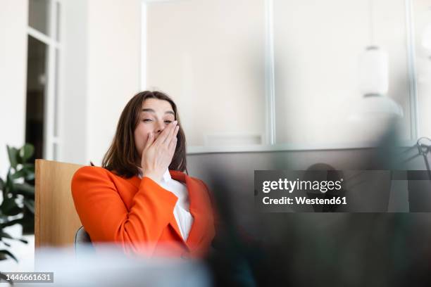 tired businesswoman yawning in office - yawn office stockfoto's en -beelden