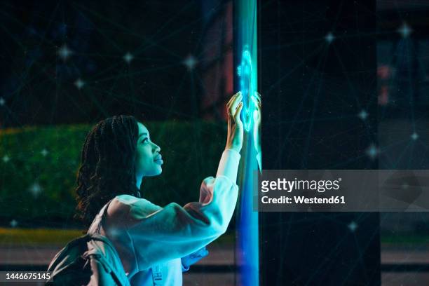 young woman experimenting immersive experience at night - interface dots imagens e fotografias de stock