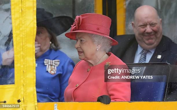 Britain's Queen Elizabeth II rides aboard an amphibious vehicle, known as a 'Yellow Duckmarine' in Liverpool, north-west England, on May 17, 2012....