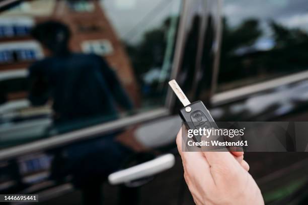 hand of man unlocking car using key - car keys hand stockfoto's en -beelden