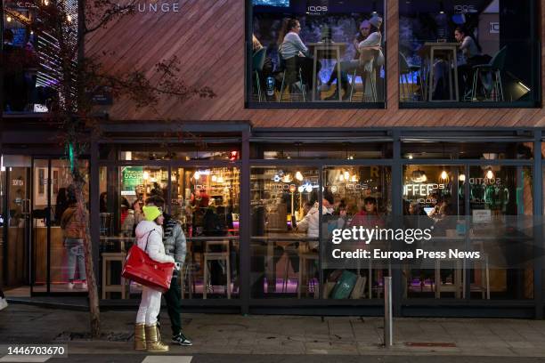 Woman waits at the entrance of a restaurant on Meritxell Avenue, December 3 in Andorra la Vella, Principality of Andorra. Tourism movement in the...