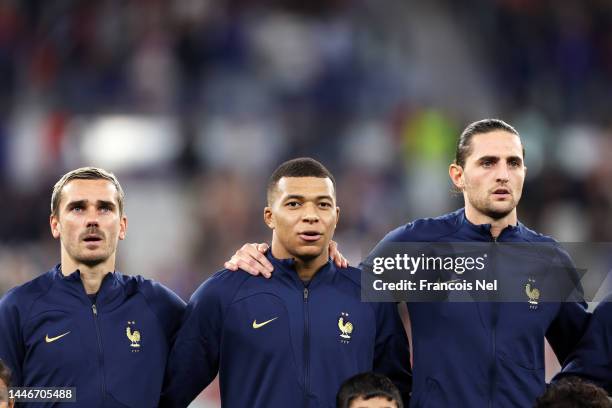 Antoine Griezmann, Kylian Mbappe and Adrien Rabiot of France line up for the national anthem prior to the FIFA World Cup Qatar 2022 Round of 16 match...